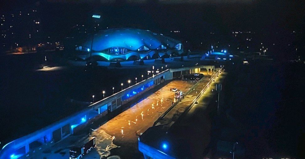 Aerial night view of a lit venue in blue and amber