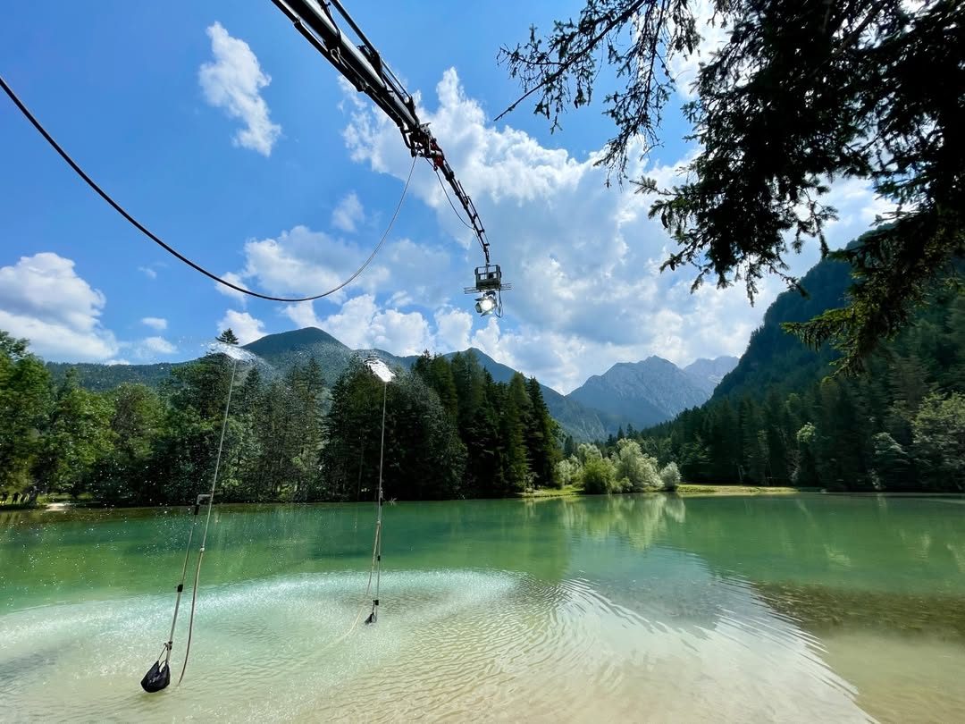 Crane arm reaching over a turquoise alpine lake