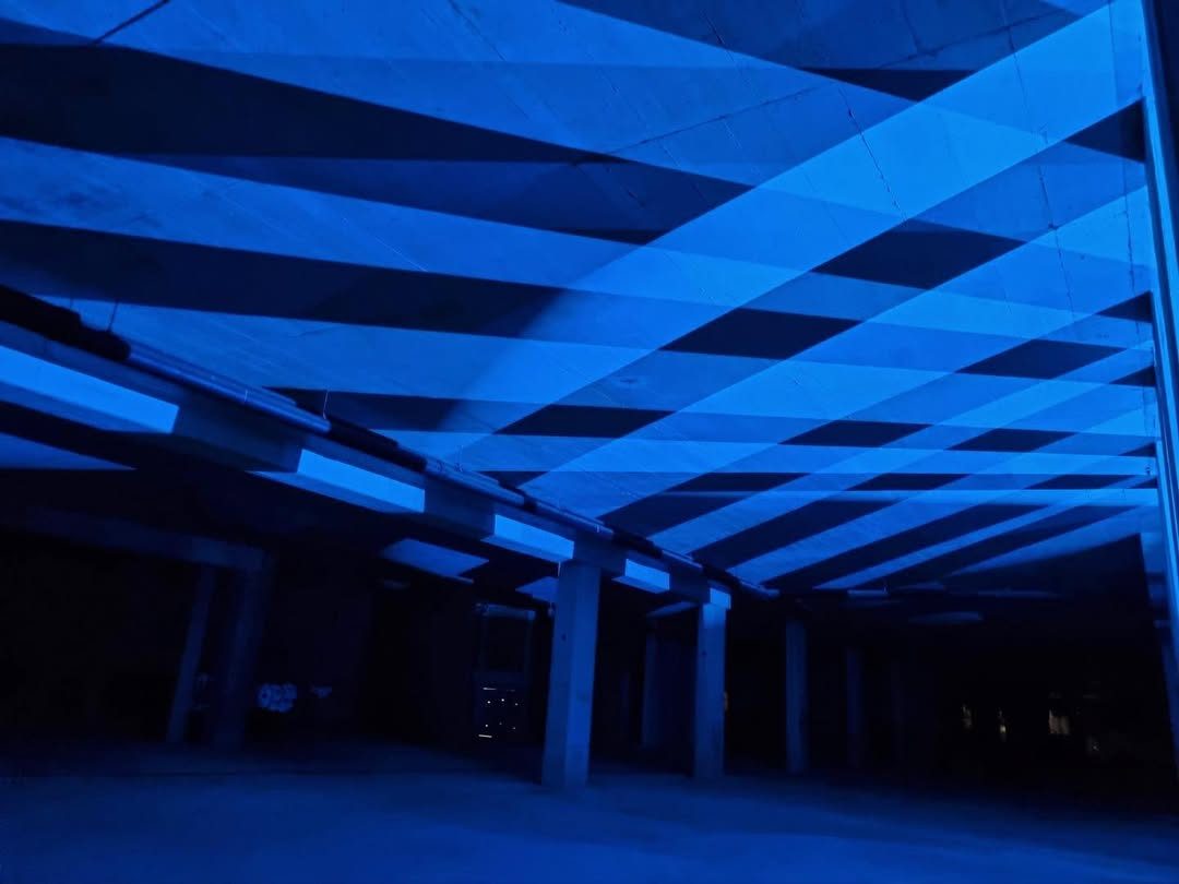 Underground garage raked with diagonal blue light stripes