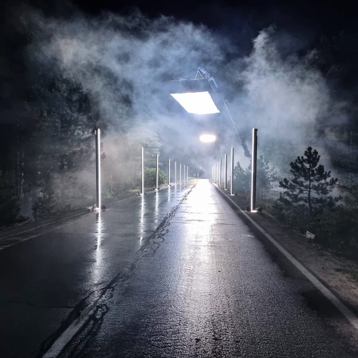 Soft light over a wet promenade in heavy mist at night