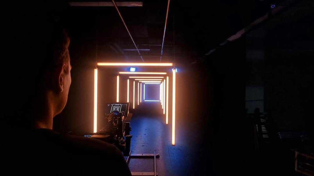 Silhouette facing a corridor of glowing orange light frames