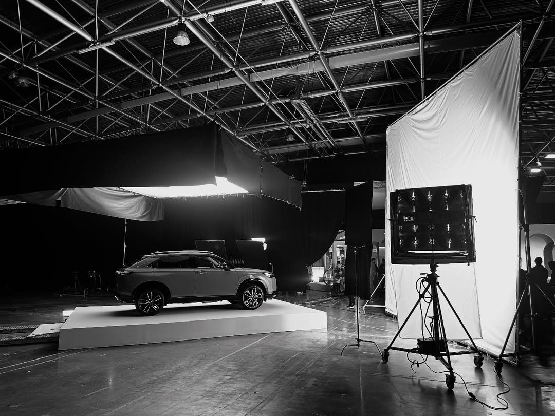 Black-and-white studio with an SUV on a white cyclorama and a large LED panel
